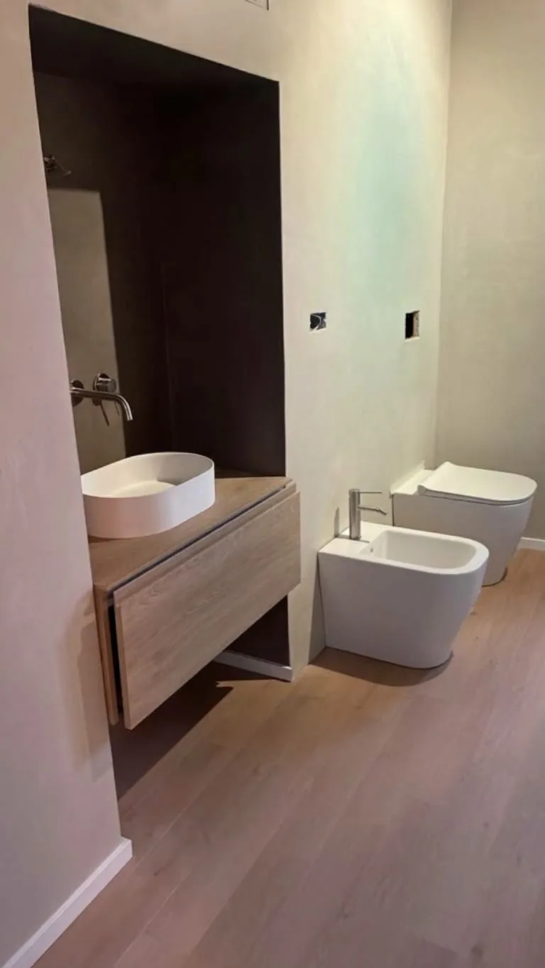 Il bagno realizzato, con mobile sospeso in legno e lavabo d'appoggio